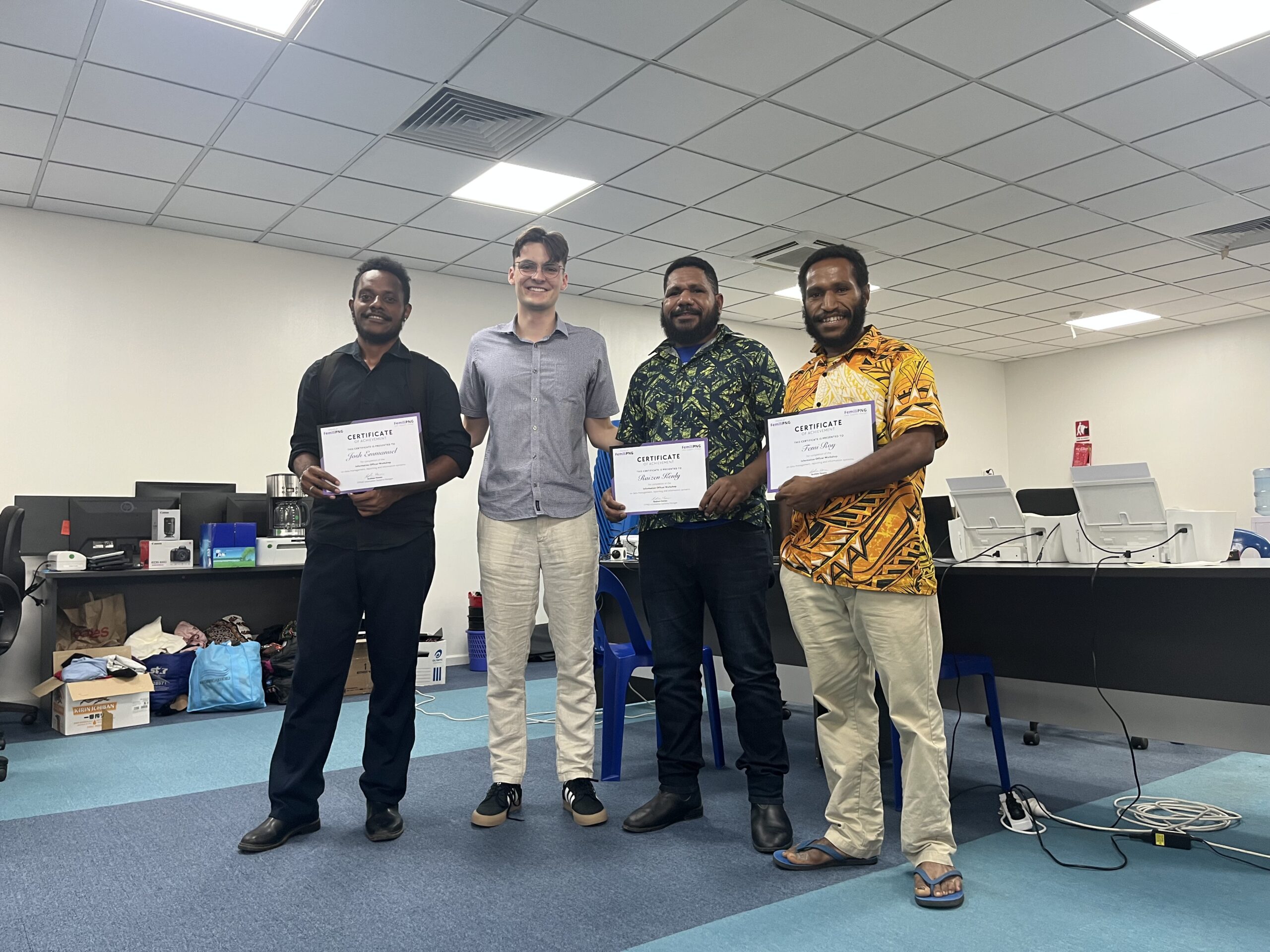 Femili PNG Information Officers receive certificates from FemiliPNG Australia after the workshop. From left to right, Joash Emmanuel, Andrew Howes, Raizen Kenly and Femi Roi.